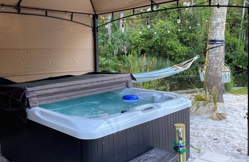 Weeki Wachee Gardens House | River Beach Retreat: with Tiki Bar, Fire Pit, Hot Tub & Clear Kayak